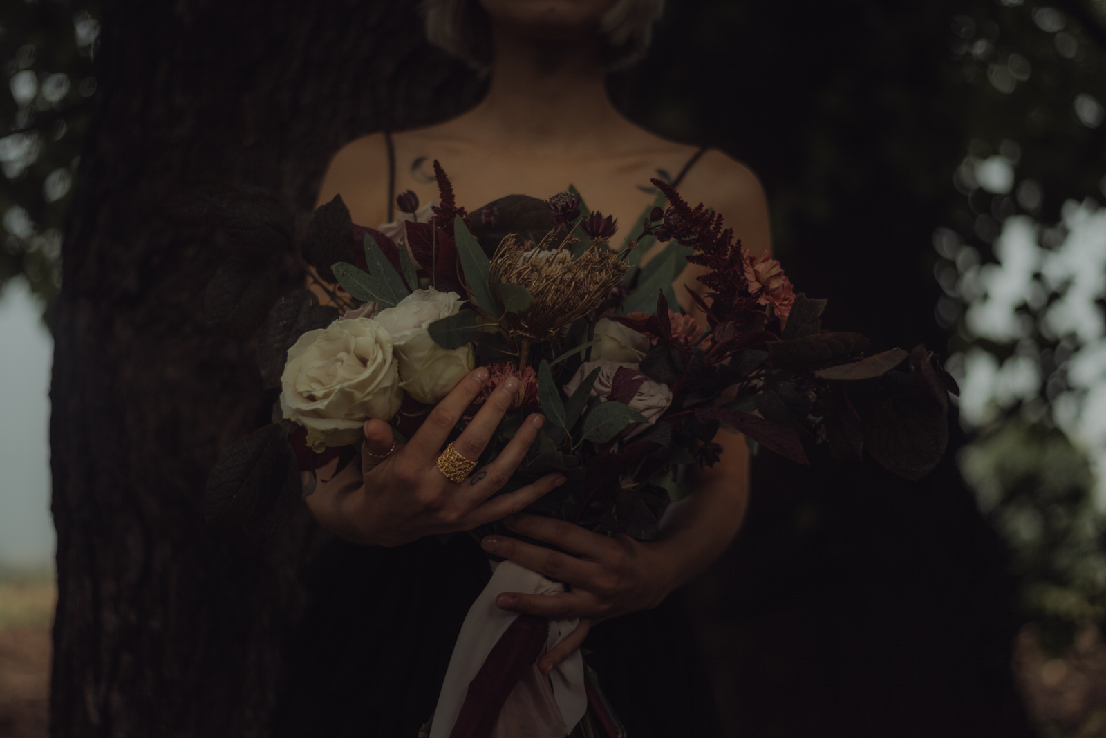 Dark rock'n'roll bride holding the bridal bouquet, italy